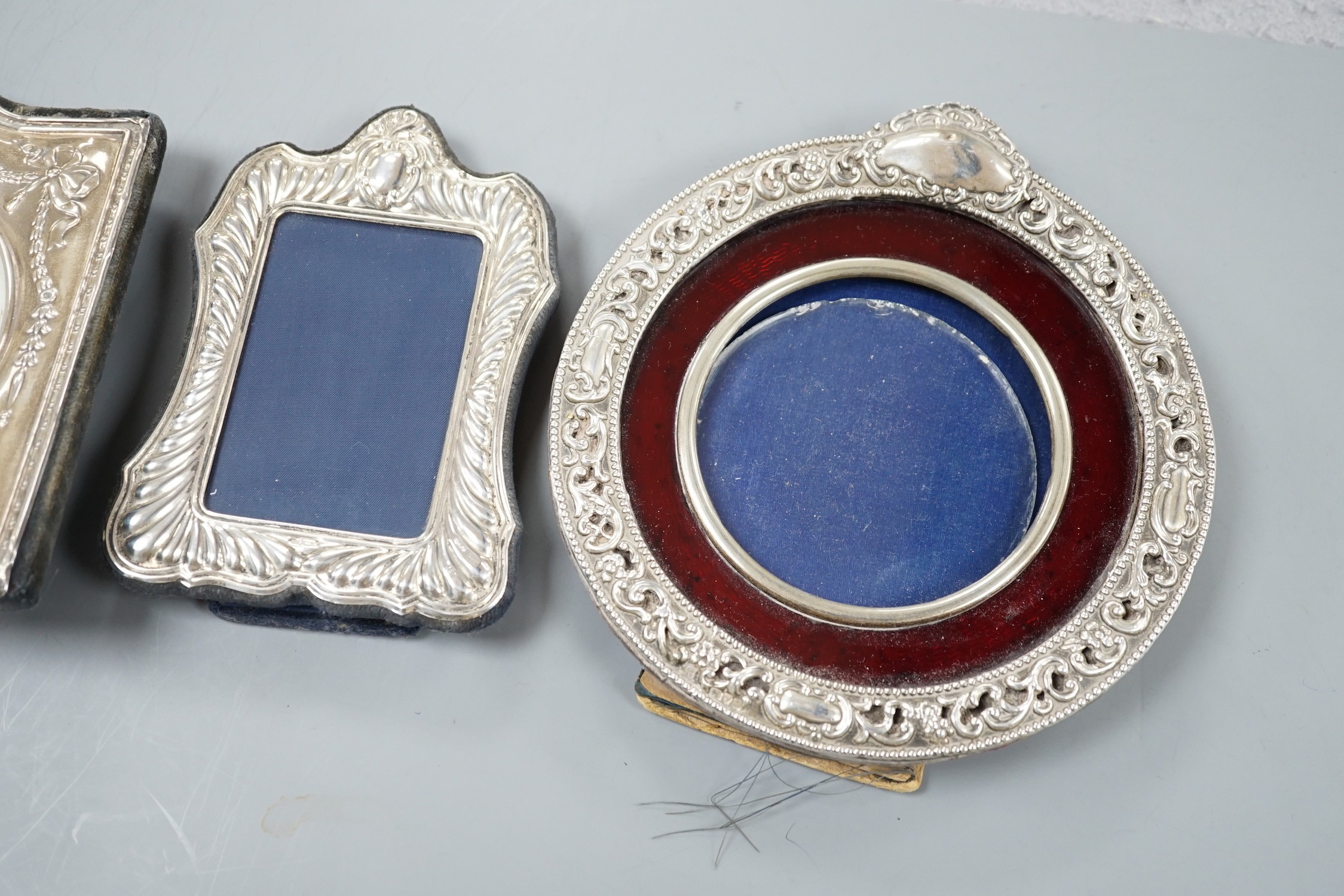 A modern silver mounted desk timepiece, 15.2cm and two mounted photograph frames, including Italian 925 and Edwardian repousse.